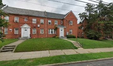 Washington apartment for rent - a red brick building with white doors and a lawn
