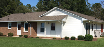 Bladenboro apartment for rent - a white house with a brown roof and a green lawn