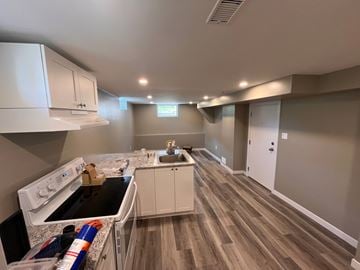Kitchener apartment for rent - a kitchen with white cabinets and a counter top and a sink