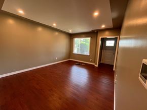 Kitchener apartment for rent - a empty living room with wooden floors and a window
