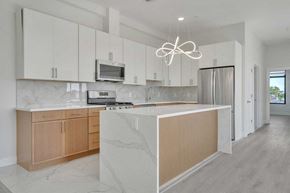 Paterson apartment for rent - a white kitchen with wooden cabinets and a large island