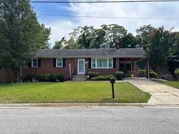 Suitland house for rent - a red brick house with a lawn and a parking meter