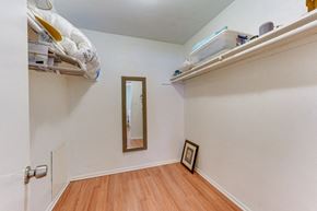 Sarasota house for rent - a bedroom with a closet and a mirror and a shelf on the wall