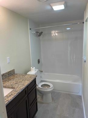 Orlando house for rent - A bathroom with a toilet, sink, and bathtub.