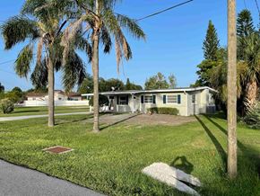 Orlando house for rent - A house with a green lawn and palm trees in front.