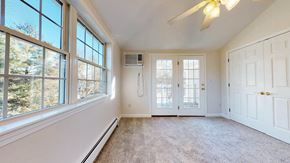 Pepperell apartment for rent - A room with a ceiling fan and a window overlooking trees.