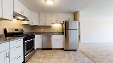 Pepperell apartment for rent - A kitchen with white cabinets and a black countertop.
