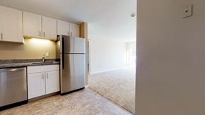 Pepperell apartment for rent - A kitchen with a refrigerator, dishwasher, and cabinets.