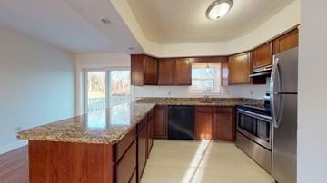 Pepperell apartment for rent - A kitchen with wooden cabinets and granite countertops.
