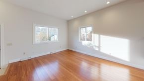 Pepperell apartment for rent - A room with wooden floors and two windows letting in sunlight.