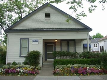 Davis apartment for rent - A small white house with a flower bed in front.