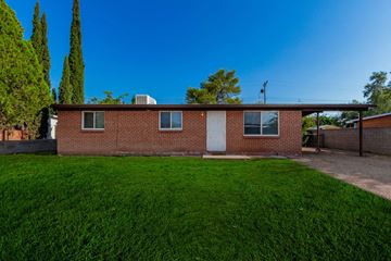 Tucson house for rent - a brick house with a lawn in front of it