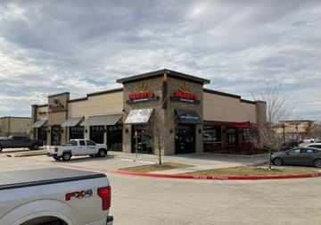 Mckinney apartment for rent - the facade of a shopping center with cars parked outside