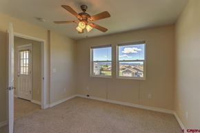 Pagosa Springs house for rent - A room with a ceiling fan and two windows.
