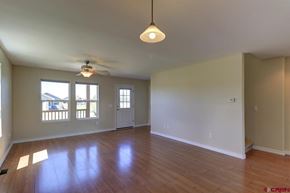 Pagosa Springs house for rent - A spacious room with a ceiling fan and wooden flooring.