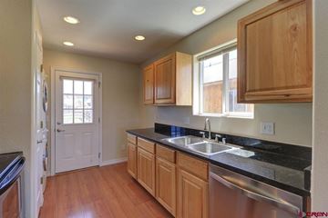 Pagosa Springs house for rent - A kitchen with wooden cabinets and a black counter top.