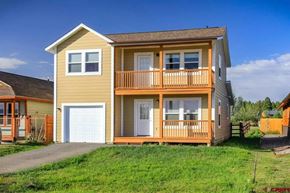 Pagosa Springs house for rent - A two-story house with a balcony and a garage.