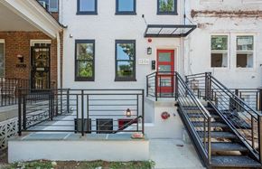 Washington apartment for rent - the front of a white house with a red door and stairs