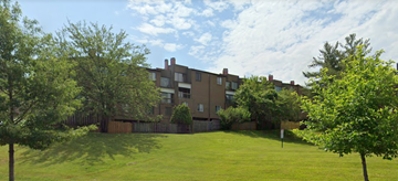 Washington apartment for rent - the backyard of an apartment building with a green lawn and trees