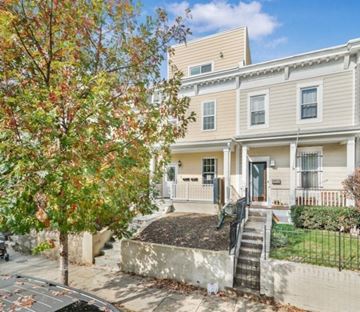 Washington apartment for rent - A tree with red and green leaves is in front of a two-story building.