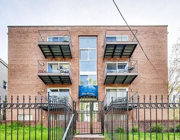 Washington apartment for rent - a brick building with three balconies and a gate