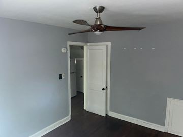 Washington apartment for rent - a bedroom with a ceiling fan and a door to a hallway
