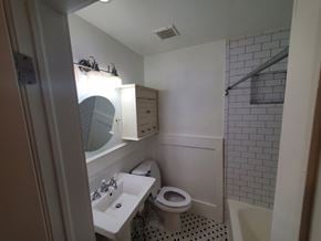 Washington apartment for rent - A bathroom with a toilet, sink, and mirror.