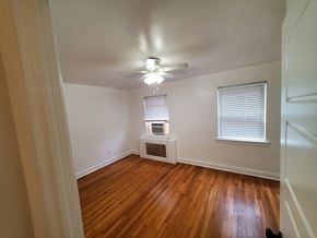 Washington apartment for rent - A room with wooden floors and a window with blinds.