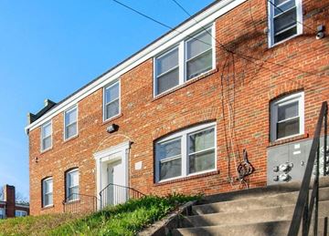 Washington apartment for rent - a brick apartment building with a white door and stairs