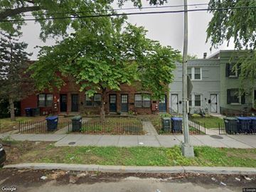 Washington apartment for rent - the front yard of a brick house with a tree and some trash cans
