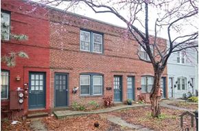 Washington apartment for rent - A red brick building with green doors and windows.
