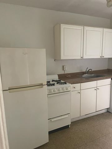 Washington apartment for rent - A white refrigerator is in a kitchen with brown countertops.