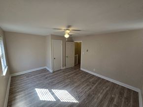 Washington apartment for rent - A room with a ceiling fan and light, wooden floors, and two doors.