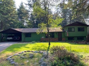 Whitefish apartment for rent - A green house with a flag on the front porch.