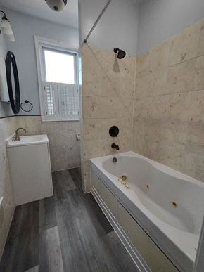 Washington apartment for rent - a bathroom with a tub and a sink and a window