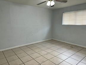 New Orleans apartment for rent - an empty room with tiled floors and a ceiling fan