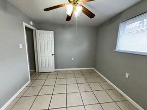 New Orleans apartment for rent - a empty room with a ceiling fan and a tiled floor