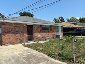 New Orleans apartment for rent - the front of a brick house with a fence