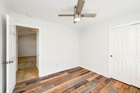 Pflugerville apartment for rent - A room with a ceiling fan and wooden flooring.