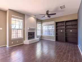 Cedar Park apartment for rent - A living room with a fireplace and a ceiling fan.