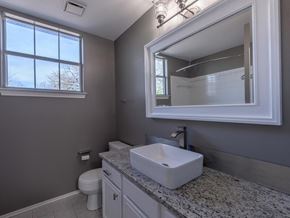 Cedar Park apartment for rent - A bathroom with a toilet, sink, and mirror.