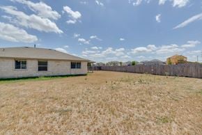 Leander apartment for rent - A large, open field with a building and a fence in the distance.