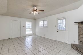 Austin apartment for rent - A spacious room with a ceiling fan and tiled flooring.