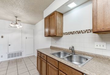 Austin apartment for rent - A kitchen with a sink and wooden cabinets.