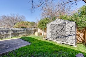 Austin apartment for rent - A shed sits in a grassy area next to a paved road.