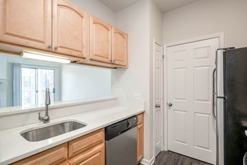Austin apartment for rent - A kitchen with wooden cabinets and a black refrigerator.