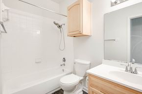 Austin apartment for rent - A white toilet sits next to a white sink in a bathroom.