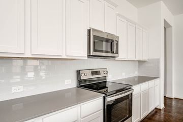 Georgetown apartment for rent - A kitchen with white cabinets and a black stove top oven.