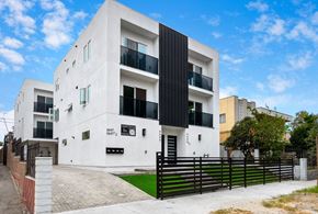 Los Angeles apartment for rent - the exterior of a white apartment building with a black fence