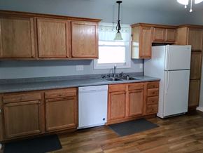 Mascoutah house for rent - a kitchen with wooden cabinets and a white refrigerator